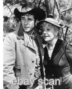 an old black and white photo of two people wearing cowboy hats standing next to each other