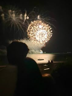 people watching fireworks on the water at night