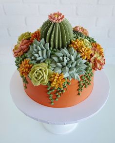 there is a cake decorated with succulents and flowers