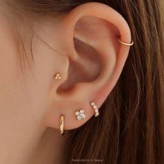 a close up of a person's ear with three different piercings