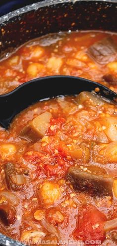 a pot full of stew with potatoes and carrots in it, ready to be eaten