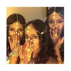 three beautiful women with henna tattoos on their faces and hands are posing for the camera