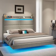 a bed with blue lights on the headboard and foot board is in a room