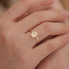 a woman's hand wearing a gold ring with the word love written on it