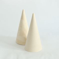 two white ceramic cones sitting on top of each other in front of a white background