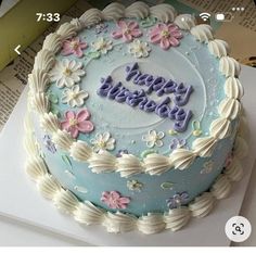 a birthday cake with flowers and the words happy birthday written in frosting on it