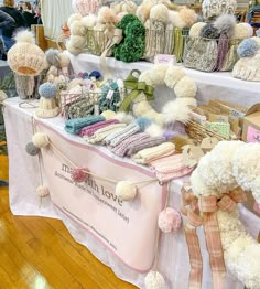 a table covered in pom poms and knitted items