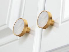 a close up of a door handle on a white door with gold trim and knobs