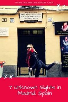 a woman riding an electric scooter in front of a building with posters on it