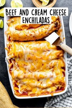 an enchiladas dish with cheese and meat in it on a table next to sliced limes