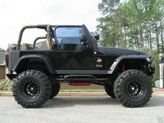 a black jeep is parked on the street