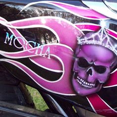 a pink motorcycle with a skull painted on it's side and the word mom written in white