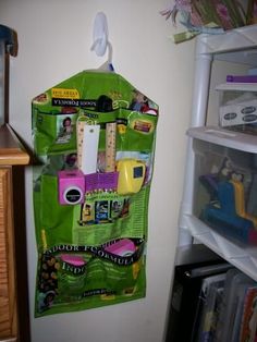 there is a green bag hanging on the wall next to a shelf with various items