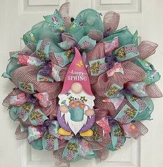 a wreath with a gnome and flowers on the front door, saying happy spring is coming