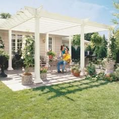 a woman sitting on a bench under a white pergoline over a patio with potted plants