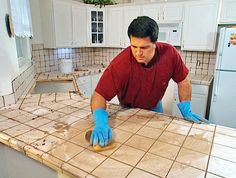 a man in blue gloves is making something on the kitchen counter top with his hands