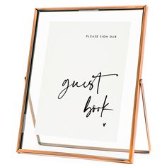 a wooden frame holds a guest book with writing on the front and back cover, along with a pen