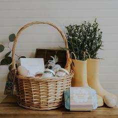 a basket filled with items sitting on top of a wooden table next to a potted plant