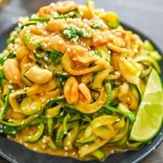 a black plate topped with noodles and vegetables