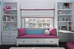 a white and blue room with a pink polka dot pillow on the futon bed