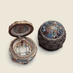 an ornately decorated box sitting on top of a white table next to it's lid