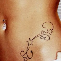 a woman's stomach with an arrow and stars tattoo on the side of her belly