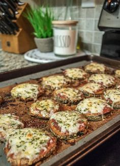 small pizzas are sitting on a baking sheet in the oven, ready to go into the oven