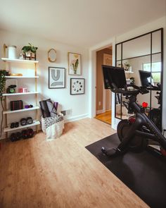 a home gym with exercise equipment in the corner and shelves on the wall behind it