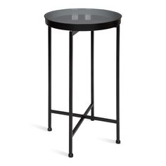 a round table with black metal legs and a glass top on an isolated white background