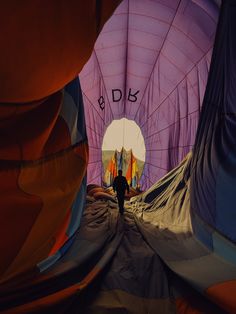 the inside of a hot air balloon with people walking through it and another person standing in the background