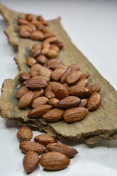 almonds are lined up on a piece of wood