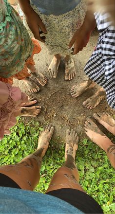 several people are standing in a circle with their hands on the ground