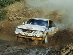 a white car driving through mud in the dirt