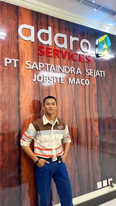 a man is standing in front of a sign that says agaro services ptt sapanidra shai jobsite maco