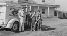 black and white photograph of people standing in front of an ice cream truck