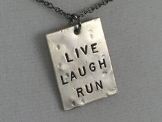 What a simple way to enjoy life! Shout out your passion! LIVE LAUGH RUN! Love your running life! Makes a great gift for anyone who is loving their training or someone who just needs a pick-me-up! Great way to brighten up a runner's tough day! The LIVE LAUGH RUN 1 Piece Necklace features a 3/4 inch wide by 1 inch long hand hammered nickel silver pendant hand stamped with LIVE LAUGH RUN horizontally down the center. Unless otherwise indicated, the LIVE LAUGH RUN necklace will arrive on an 18 inch Running Necklace, Running Jewelry, Motivational Jewelry, Fitness Fun, Natural High, Custom Pendants, Silver Bow, Black Jewelry, Shoe Charms