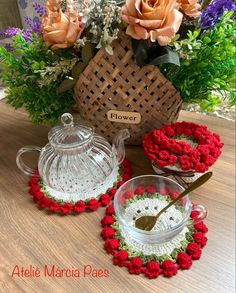 a table topped with glass dishes and vases filled with flowers