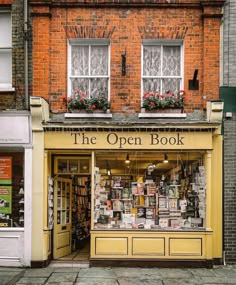 an open book store on the corner of a street in front of a brick building