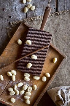 some nuts are on a wooden tray next to a spoon