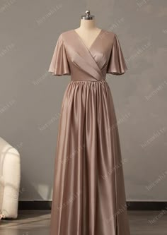 This V-Neck Long Short Sleeve Silk Satin Bridesmaid Dress is crafted from the finest silk satin for an exquisite look. The bell sleeve, pleated bodice, and skirt all contribute to a sophisticated silhouette, while the custom colors ensure you find the perfect shade to complement your special day. A back zipper finishes this luxurious bridesmaid dress. Fabric: Silk Stain Silhouette: A-line Length: Floor-Length Straps & Sleeves: Sleeves Back Style: Back Zip Fully Lined: Yes Built-In Bra: Yes Bonin Satin Gown Bridesmaid With Sleeves, Silk Long Dress Satin, Stain Dress, Bridesmaid Dresses Sleeves Short, Bridesmaid Dresses Silk Satin, Bridesmaid Dresses Satin Long, Bridesmaid Dresses Silk Satin With Sleeves, Bridesmaid Silk Dresses, Satin Outfits For Women