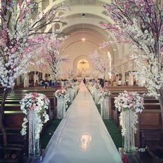 the aisle is decorated with pink and white flowers, as well as trees in bloom