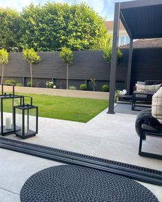 an outdoor living area with black furniture and grass