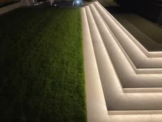 an outdoor area with grass and steps lit up at night