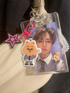 a keychain with an image of a person wearing glasses and holding a teddy bear