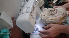 someone is using a sewing machine to sew fabric on a piece of cloth that has been rolled over