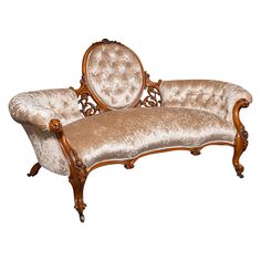 an antique style couch with ornate carved wood frame and upholstered fabric on the back