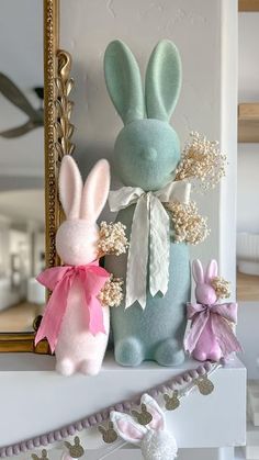 two stuffed animals sitting on top of a mantle next to a mirror and string garland