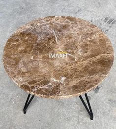 a marble coffee table with black legs and the word hxm written on it