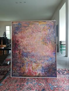 an abstract painting is on display in the middle of a room with chairs and tables