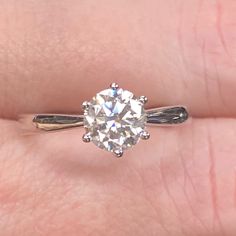 a woman's hand with a ring on it and a diamond in the middle